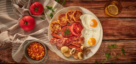 English breakfast: spicy beans in tomatoes, beef sausages, fried mushrooms, tomatoes, eggs and AVIKO Rösti pancakes